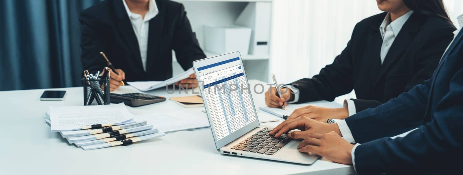 Corporate accountant team use accounting software on laptop to calculate and maximize tax refund and improve financial performance base on financial data. Modern business accounting . Shrewd