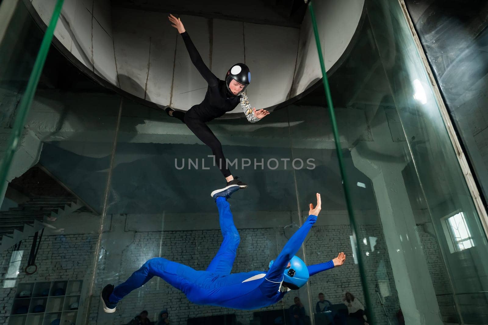 A man and a woman enjoy flying together in a wind tunnel. Free fall simulator.