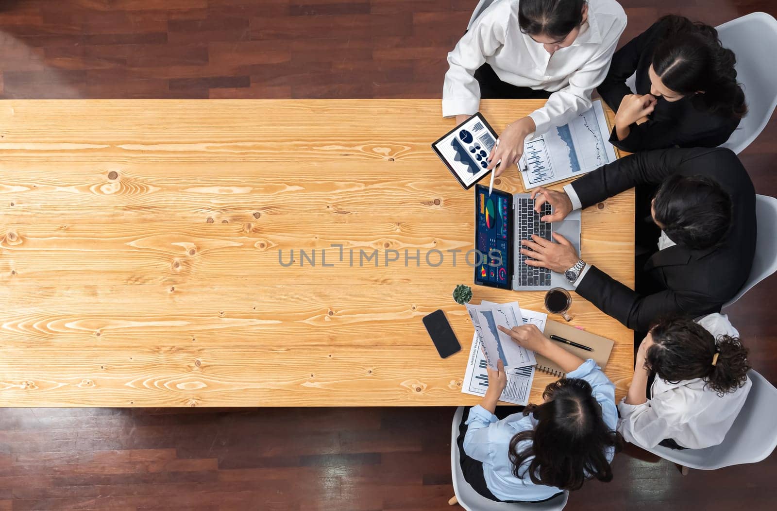 Panorama top view diverse group of business analyst team analyzing financial data report paper on meeting table. Chart and graph dashboard by business intelligence analysis. Meticulous