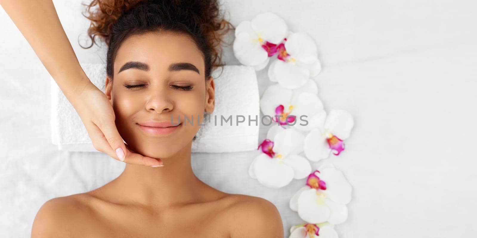 Facial beauty treatment. Woman getting face massage at beauty salon, top view