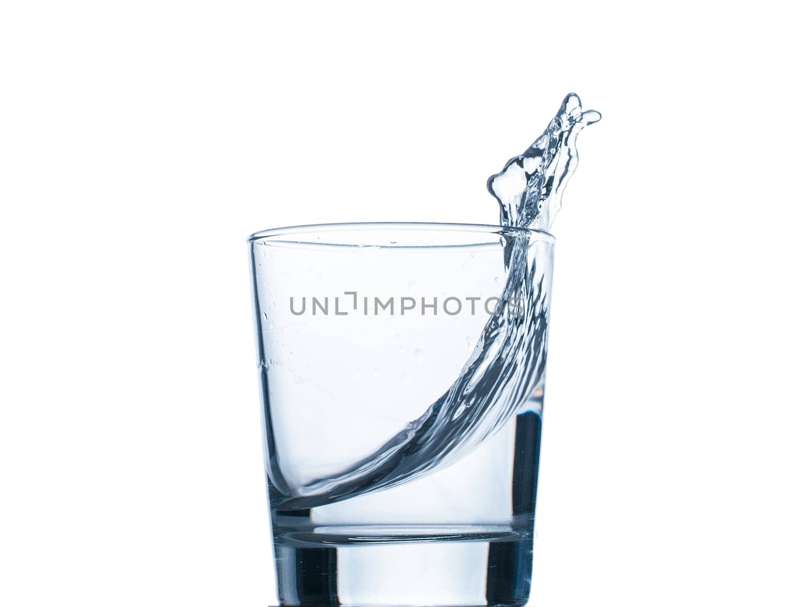 water splashing from glass isolated on white background. Water in glass close up