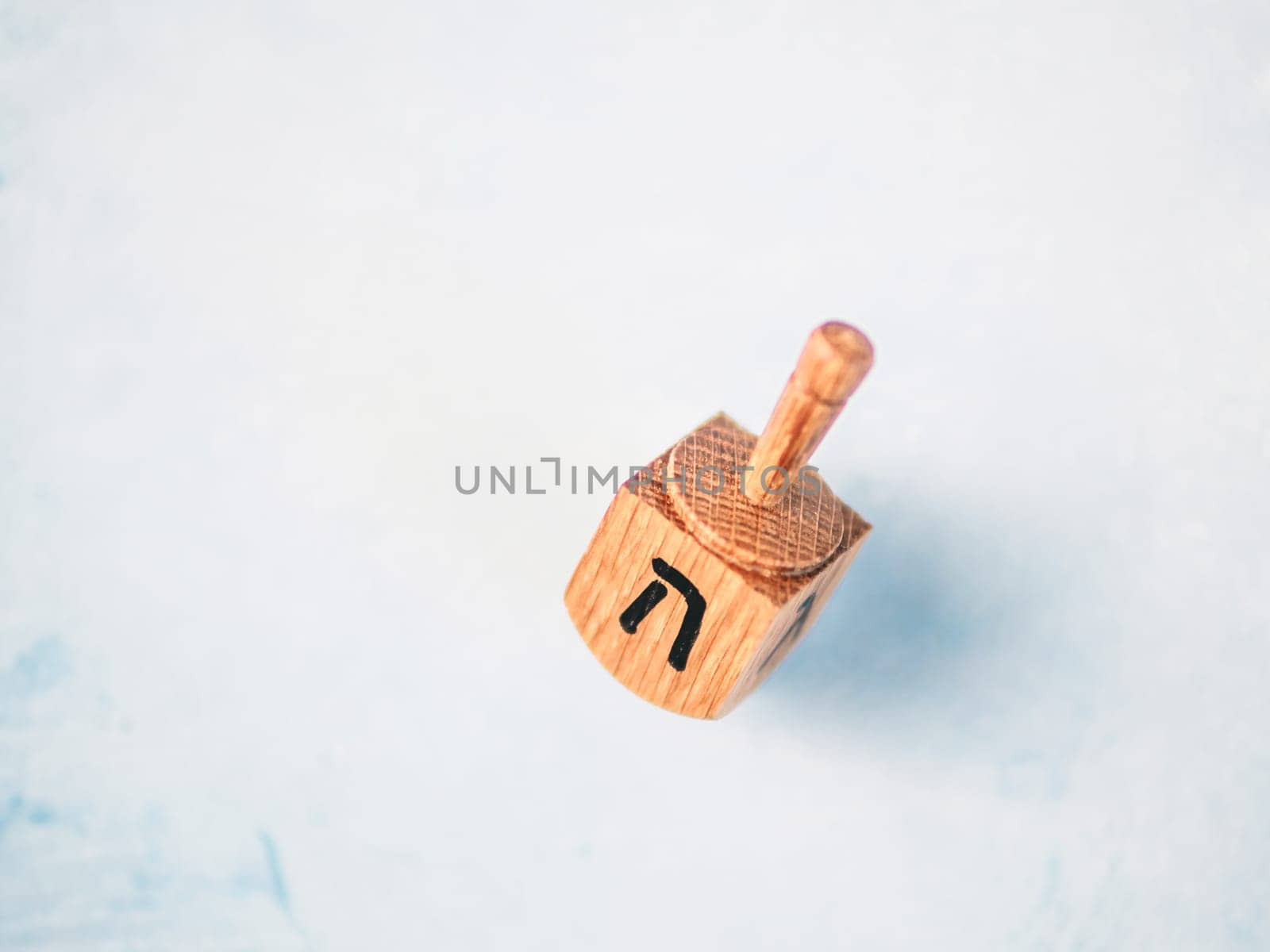 Jewish holiday Hanukkah concept and background. Hanukkah traditional spinnig dreidl or dredel on blue background. Copy space for text. Top view or flat lay.