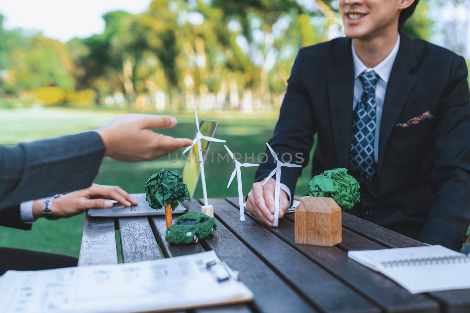 Group of asian business people presenting environmentally friendly development plan and sustainable technology project for greener future, establishing outdoor eco business office at natural park.Gyre