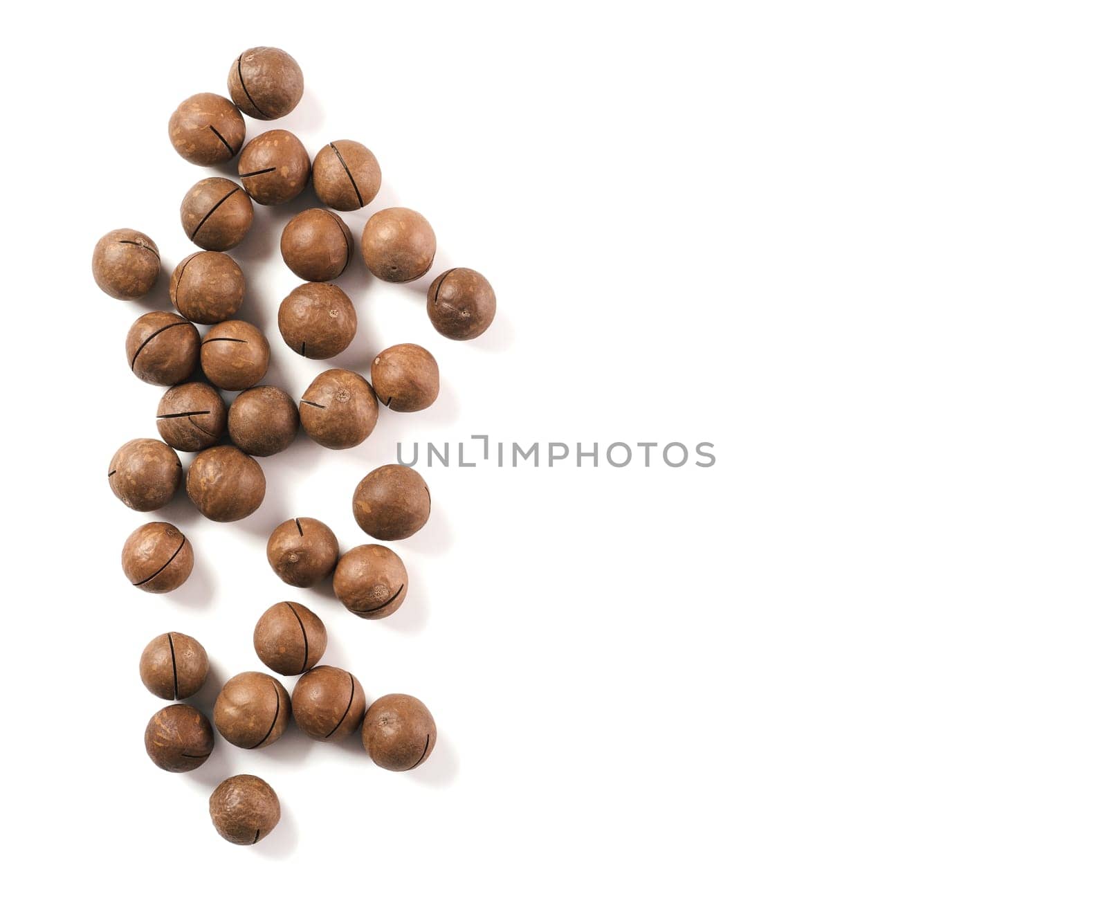 Heap of macadamia nuts on white background with clipping path.. Set of macadamia nuts isolated on white, top view or flat lay. Copy space for text.