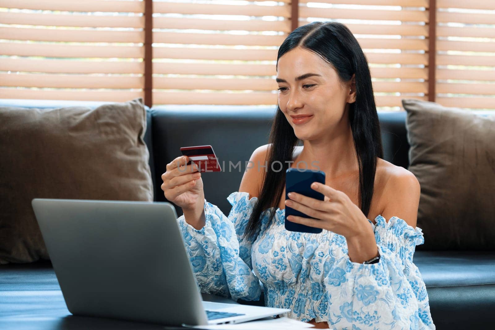 Young woman using online payment app and digital wallet on smartphone to pay with credit card. E commerce shopping and modern purchasing via mobile internet. Blithe
