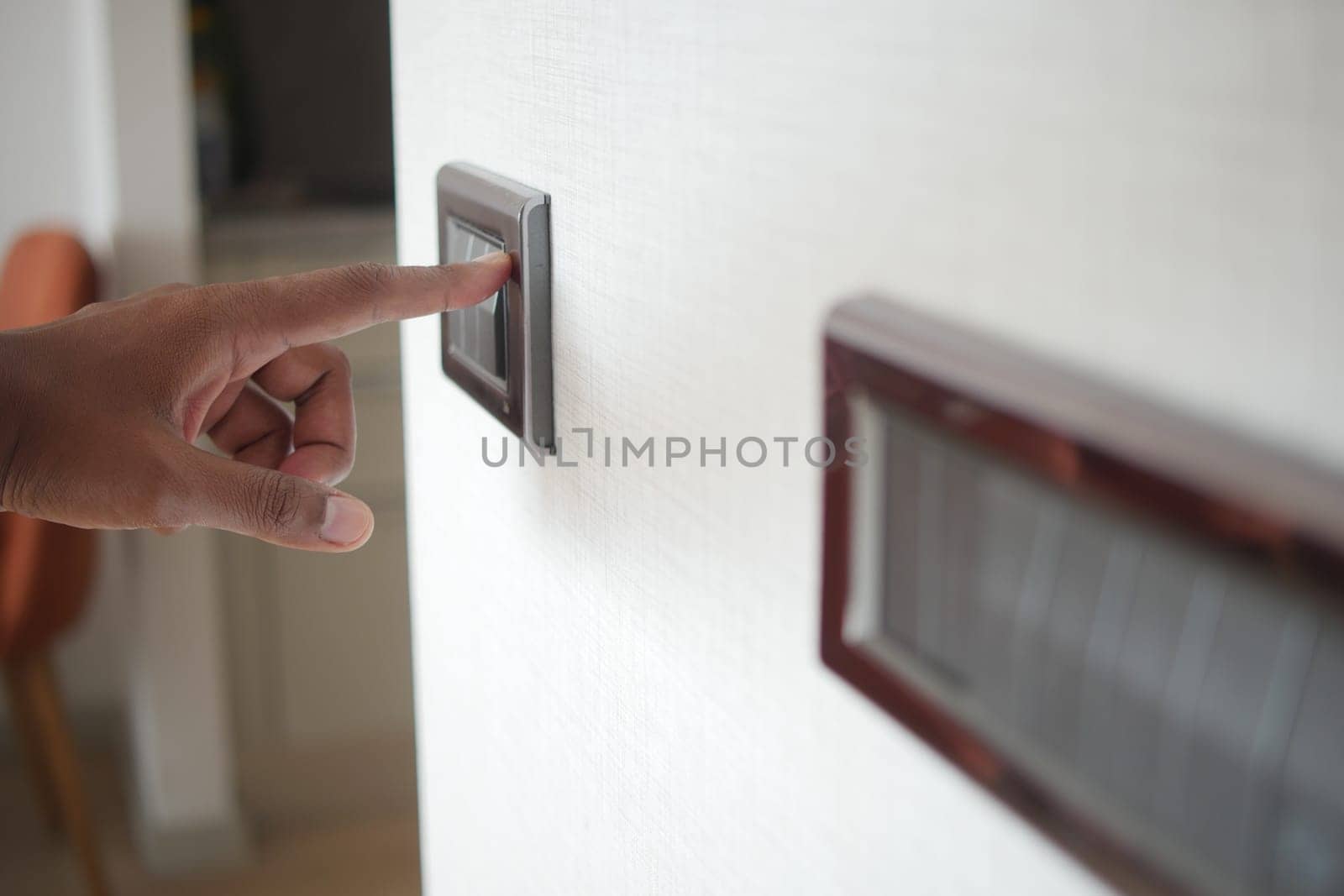 A finger turning on lighting switch
