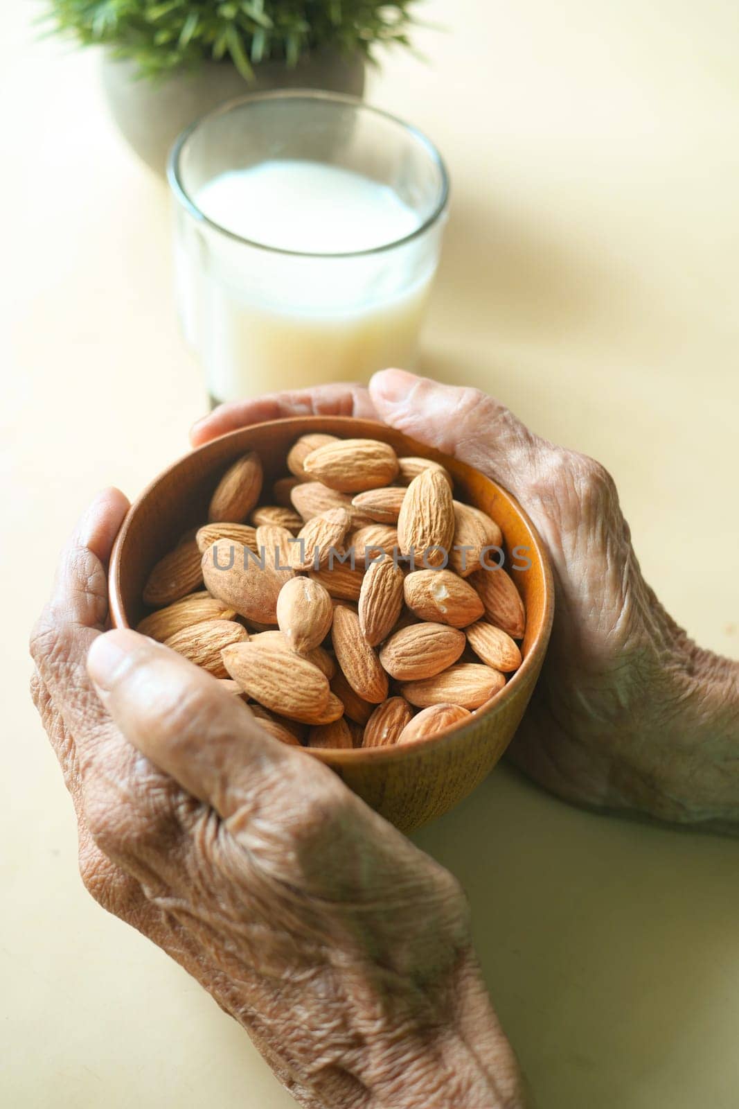 close up senior women hand holding a bowl on almond .