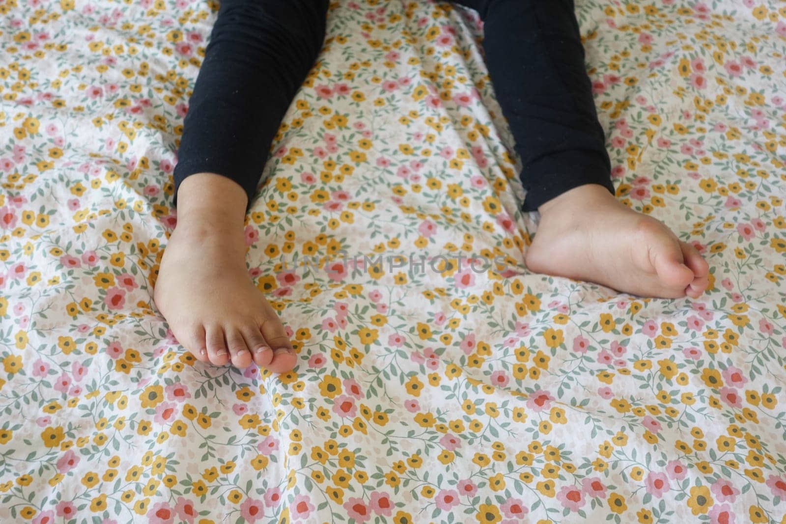 close up of dry child feet on bed