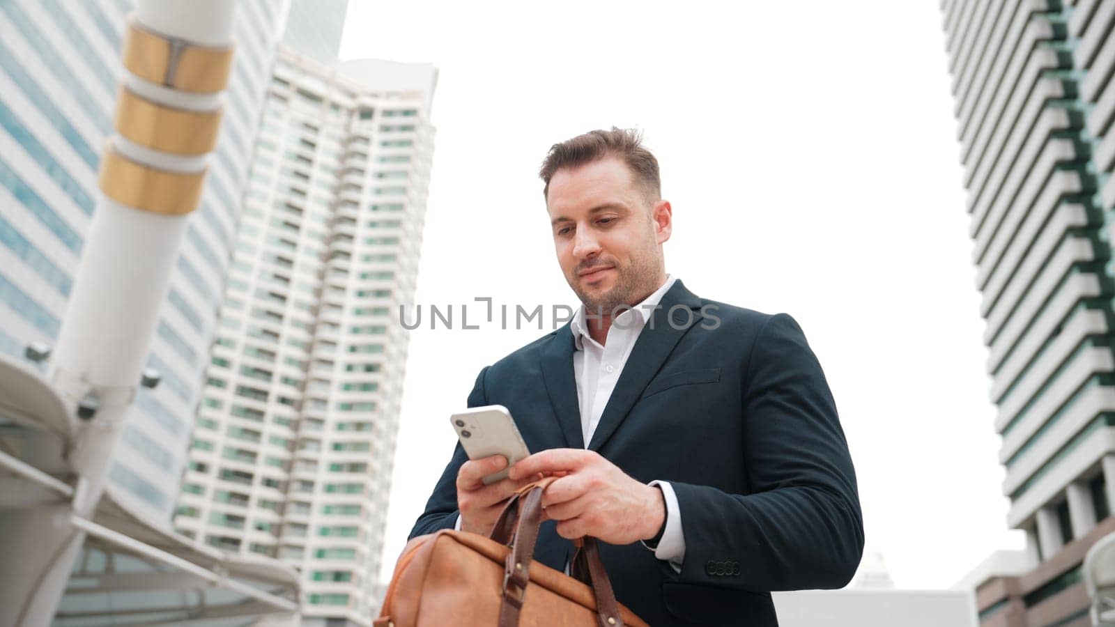 Caucasian business man checking mobile phone while standing at urban. Urbane. by biancoblue