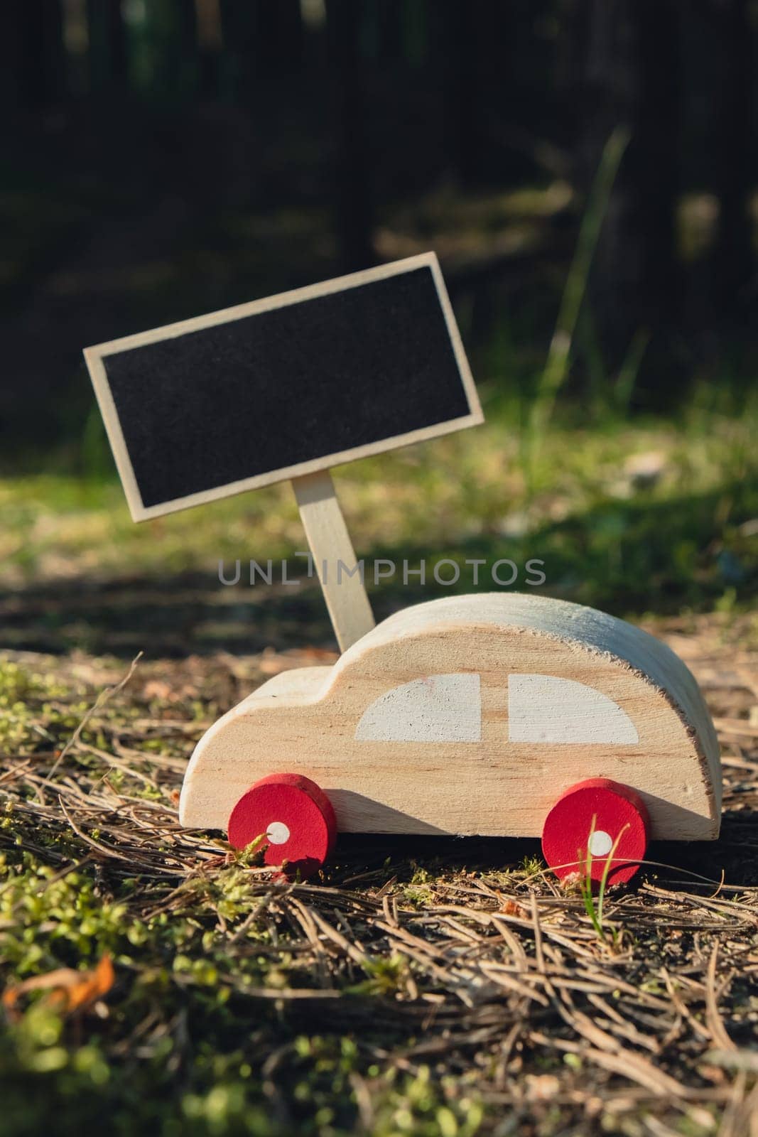 Empty blackboard with copy space Wooden toy car on greenery forest background. Eco-car concept World car free day electric vehicle environment automobile transportation electric vehicle. Hybrid electric. Sustainable engine. Zero CO2 emission for natural awareness by anna_stasiia