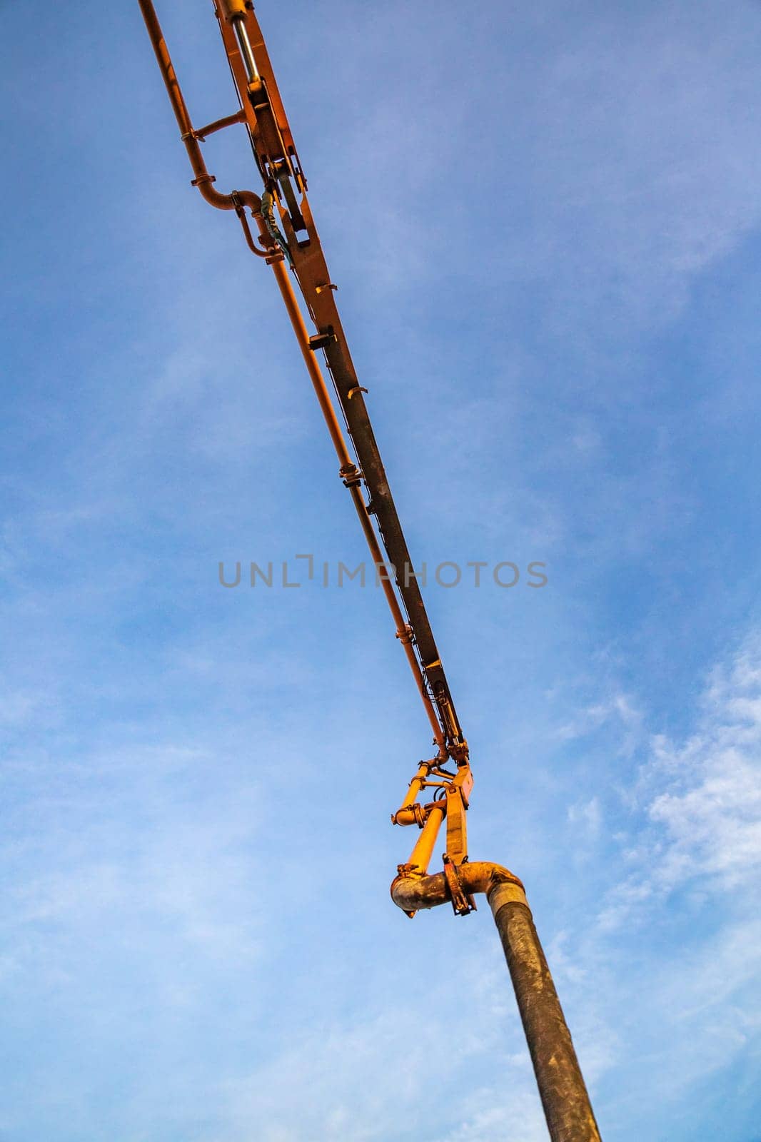 Hose on a deployed crane of a concrete pump track against the sky by Rom4ek