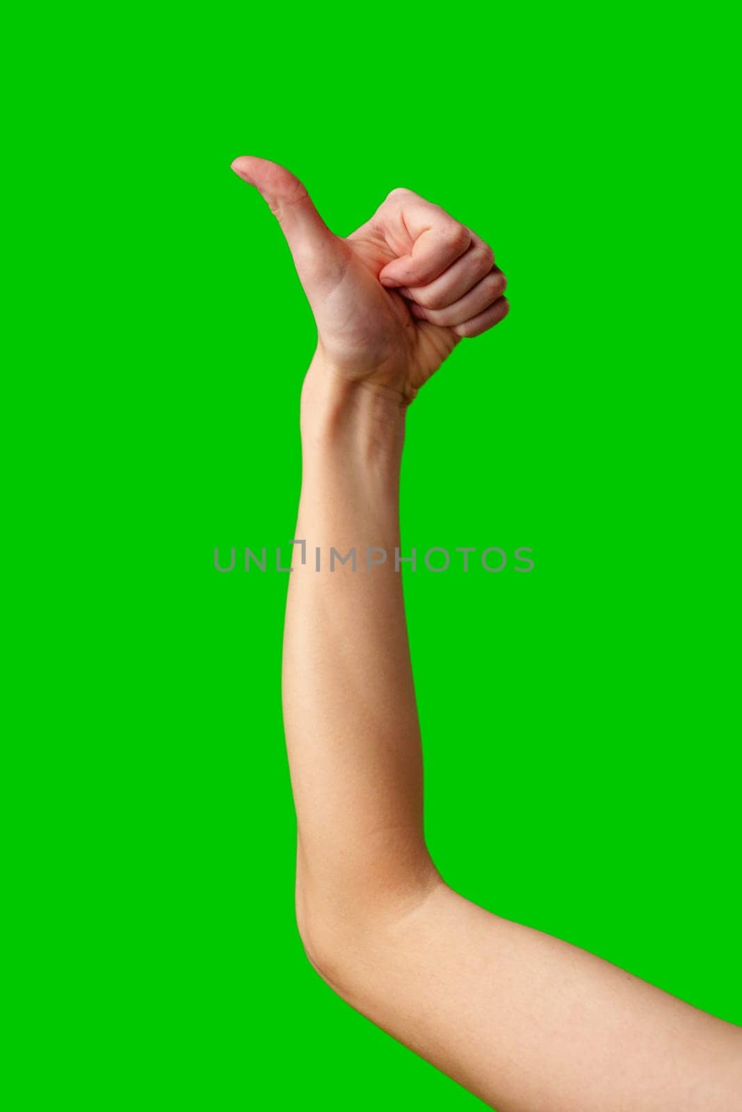 A close-up view captures the extended arm of an individual showing a thumbs up sign, denoting approval or success. The arm is poised against a vibrant green screen backdrop which is commonly used for chroma key compositing in video production and photography.
