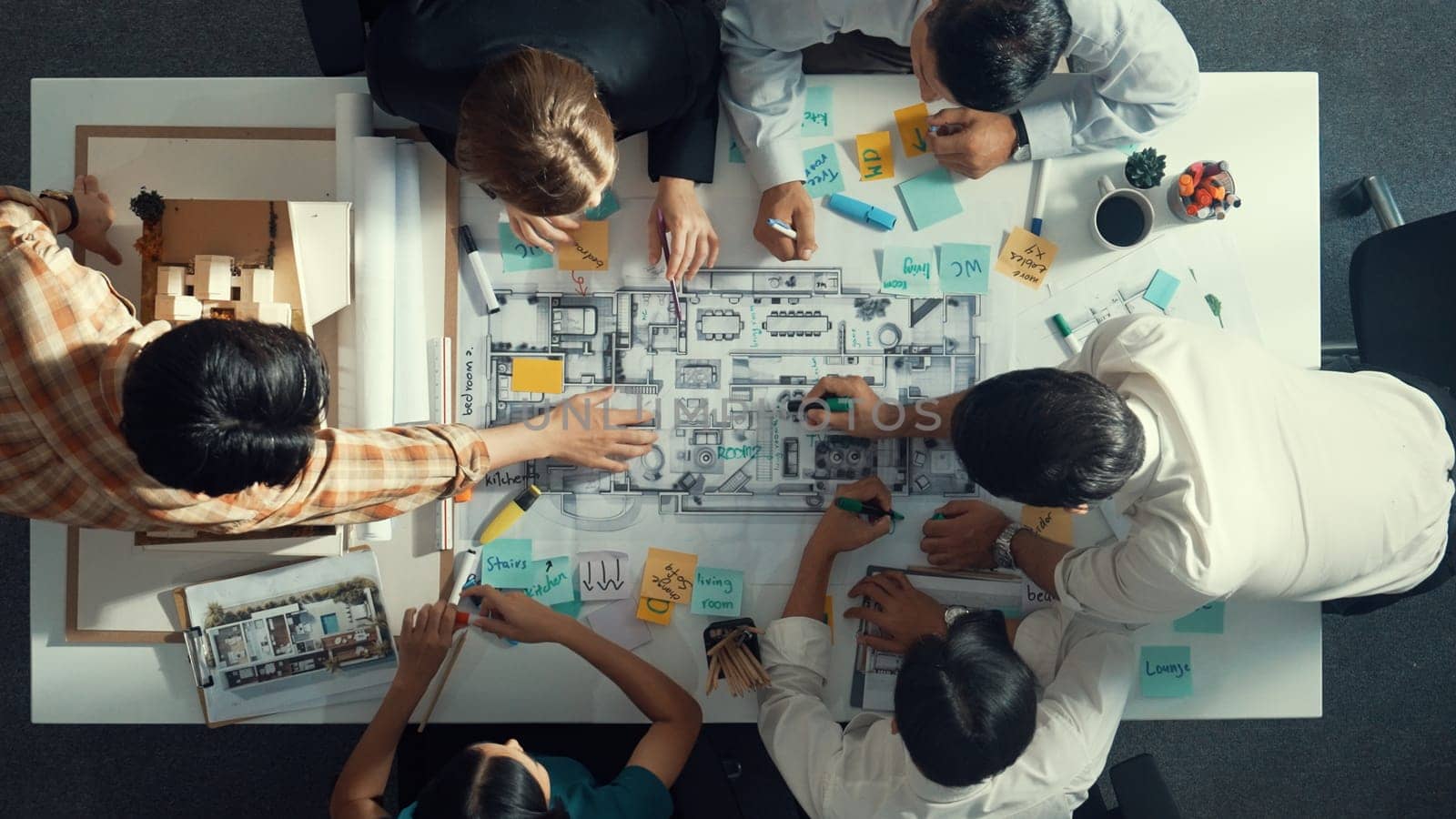 Top aerial view of project manager or civil engineer writing at blueprint and planning building design. Aerial view of architect working together at meeting table with document placed. Alimentation.