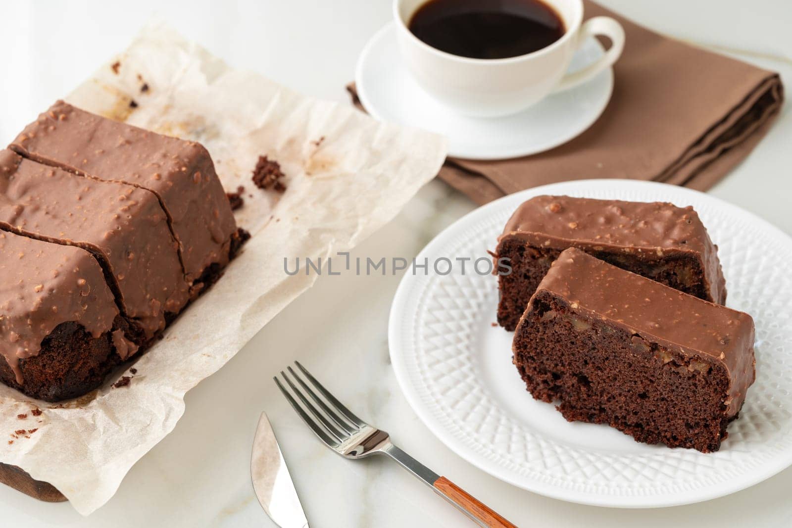 Fresh homemade chocolate sponge cake on wooden board close up