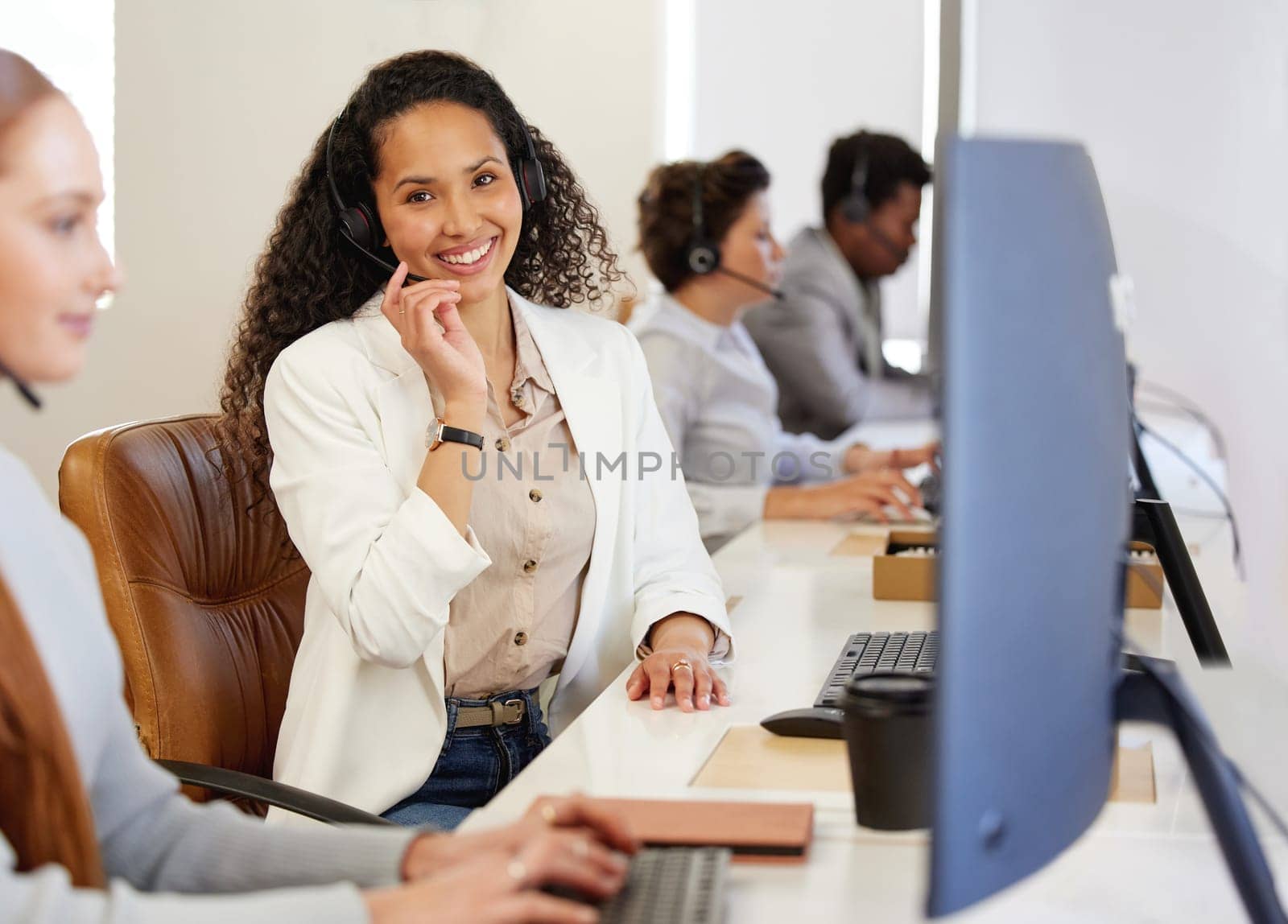 Portrait, woman and headphone with smile in working for call center or customer care in office with coworkers. Female person, consultant and agent for telecommunication, company and workplace or job by YuriArcurs