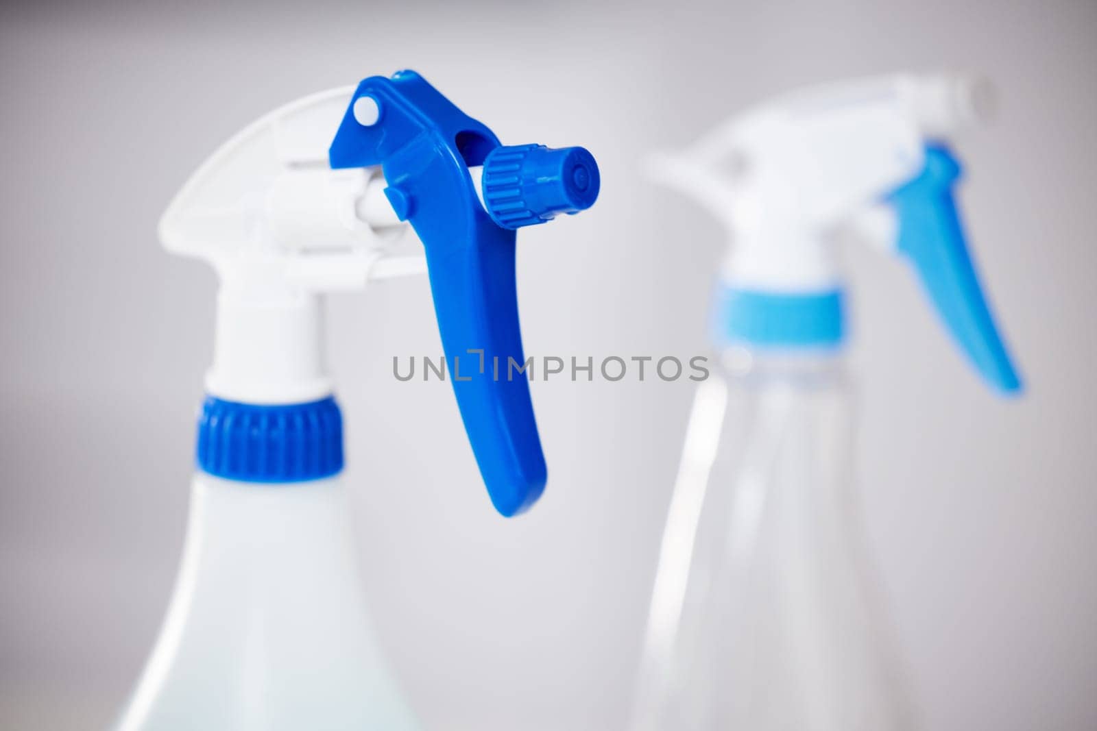 Spray, bottle and product for cleaning closeup in home or detergent in container for janitor service. Chemical, cleaner and tools for washing dirt, dust and protection from bacteria and germs by YuriArcurs