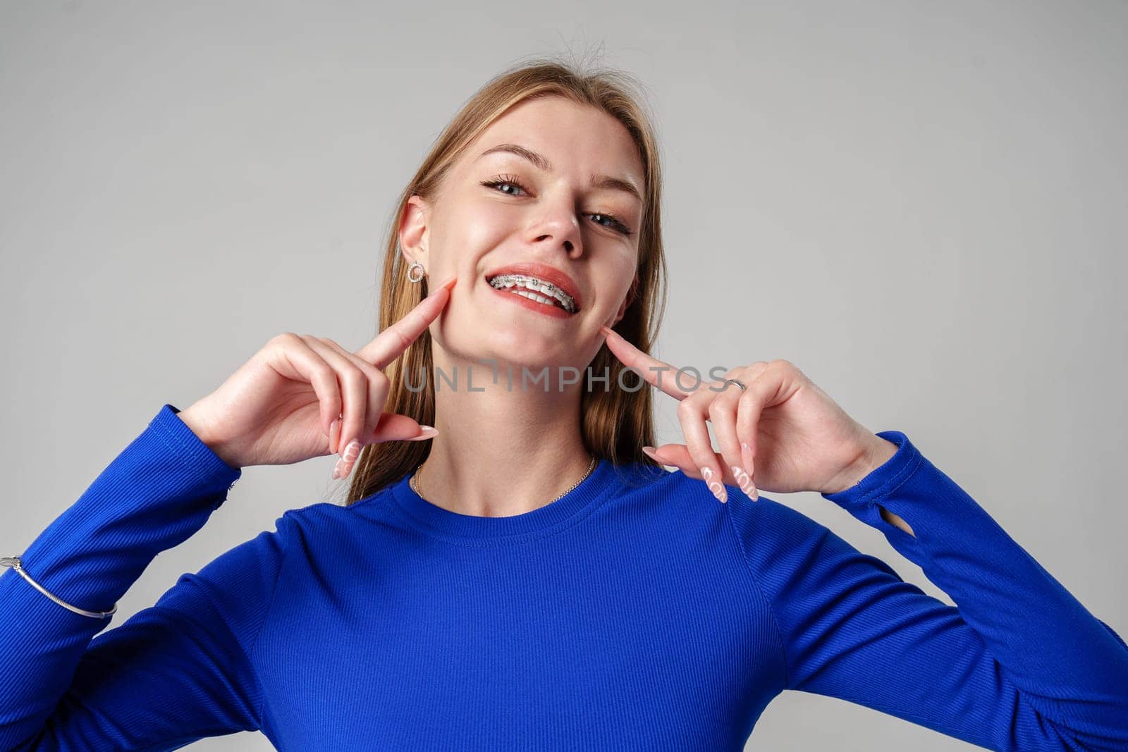 Smiling Woman in Black Top against gray background in studio