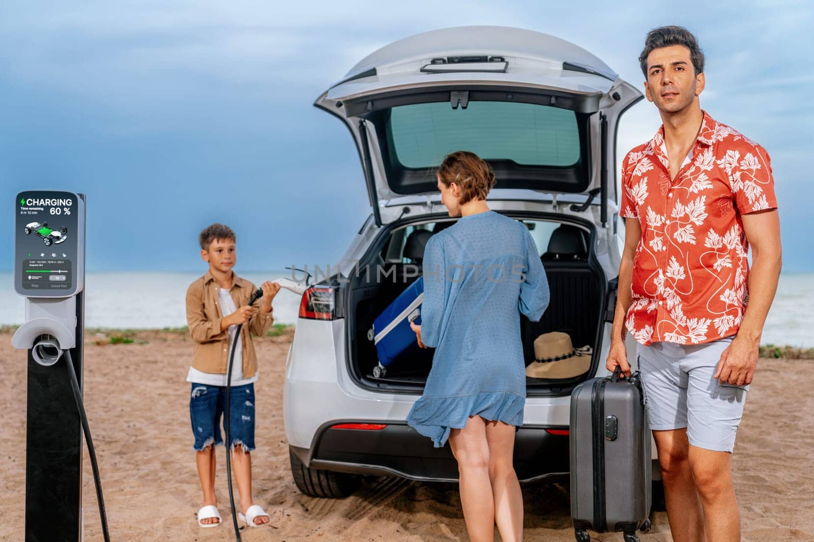 Family vacation trip traveling by the beach with electric car, lovely family taking luggage out while charging EV car battery with clean energy. Alternative family travel by eco-friendly car.Perpetual