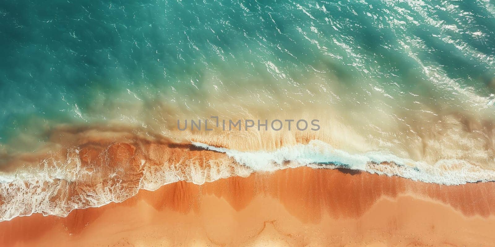 The ocean is calm and the water is a beautiful blue color. The sand is a warm orange color