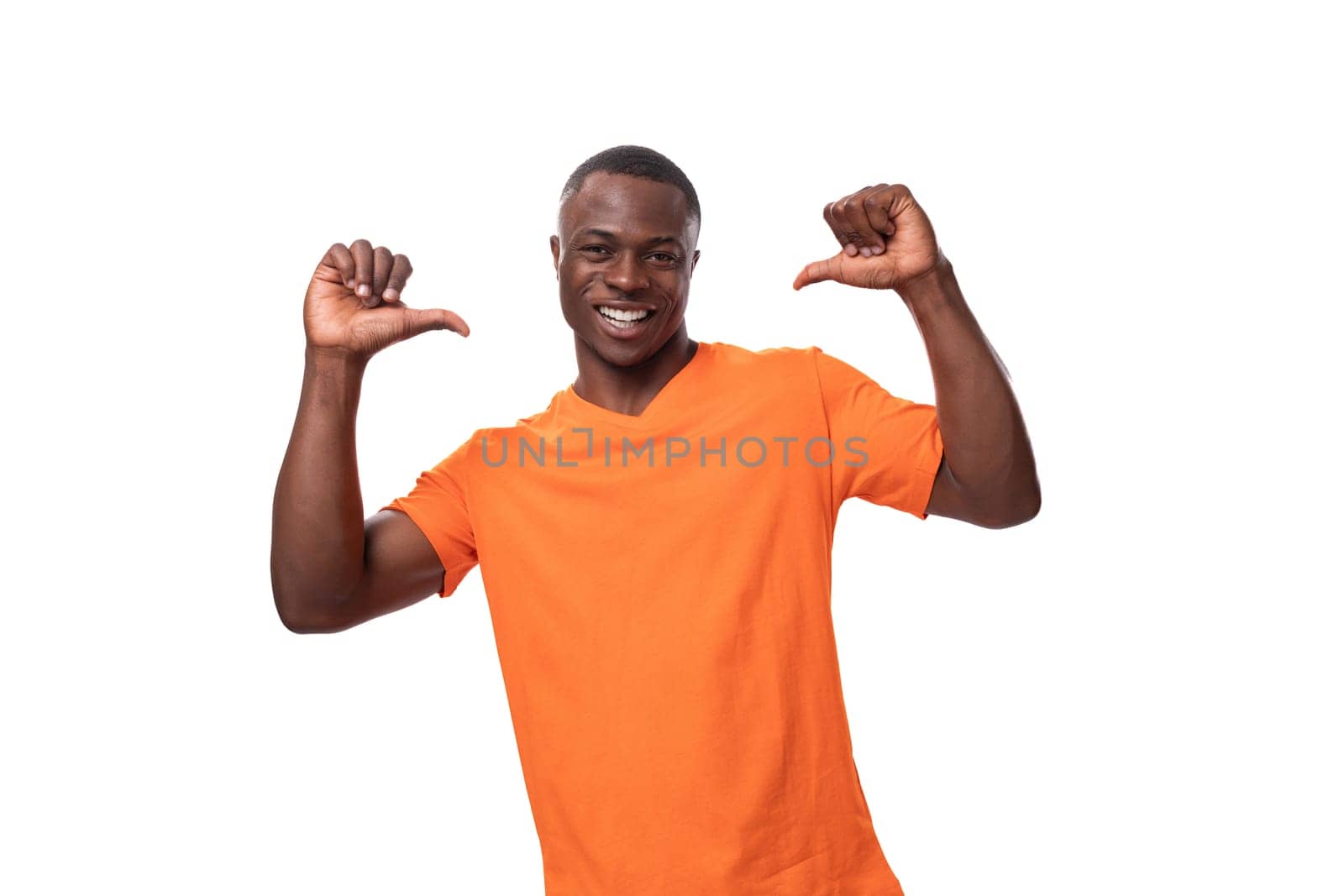 young nice kind american man dressed in an orange t-shirt on a white background with copy space.
