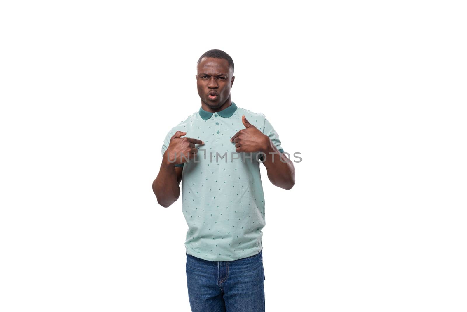 a young charismatic American guy dressed in a mint T-shirt points to himself.