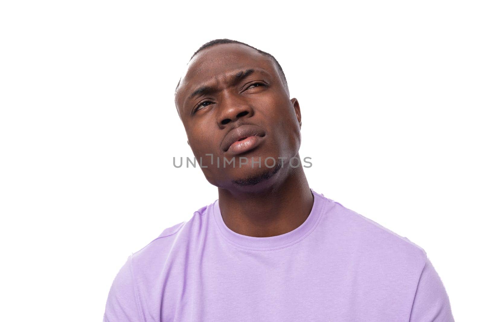 close-up portrait of a young proud american man dressed in a light lilac t-shirt on a white background with copy space.