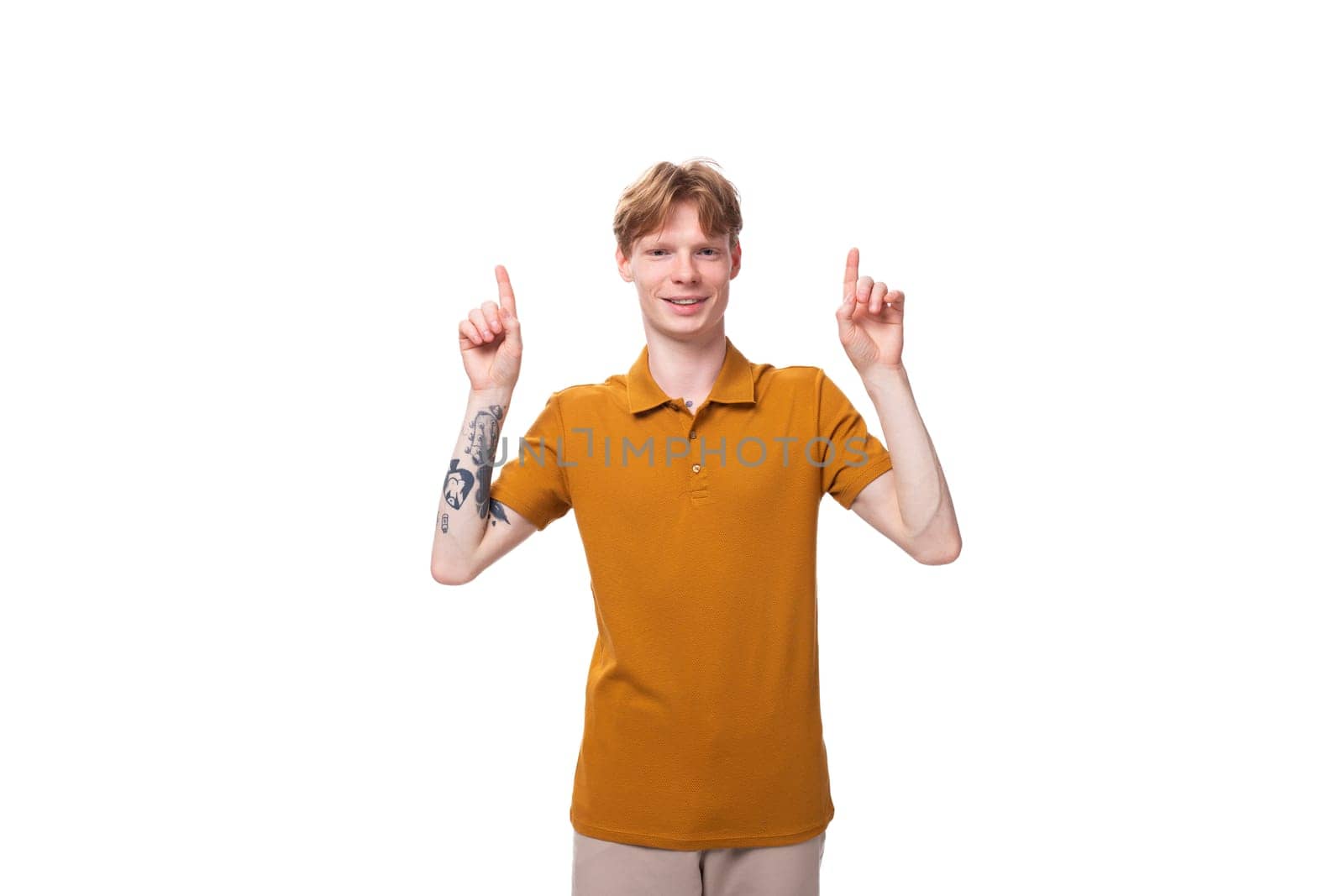 portrait of a young adorable redhead man dressed in a yellow t-shirt on a white background with copy space by TRMK