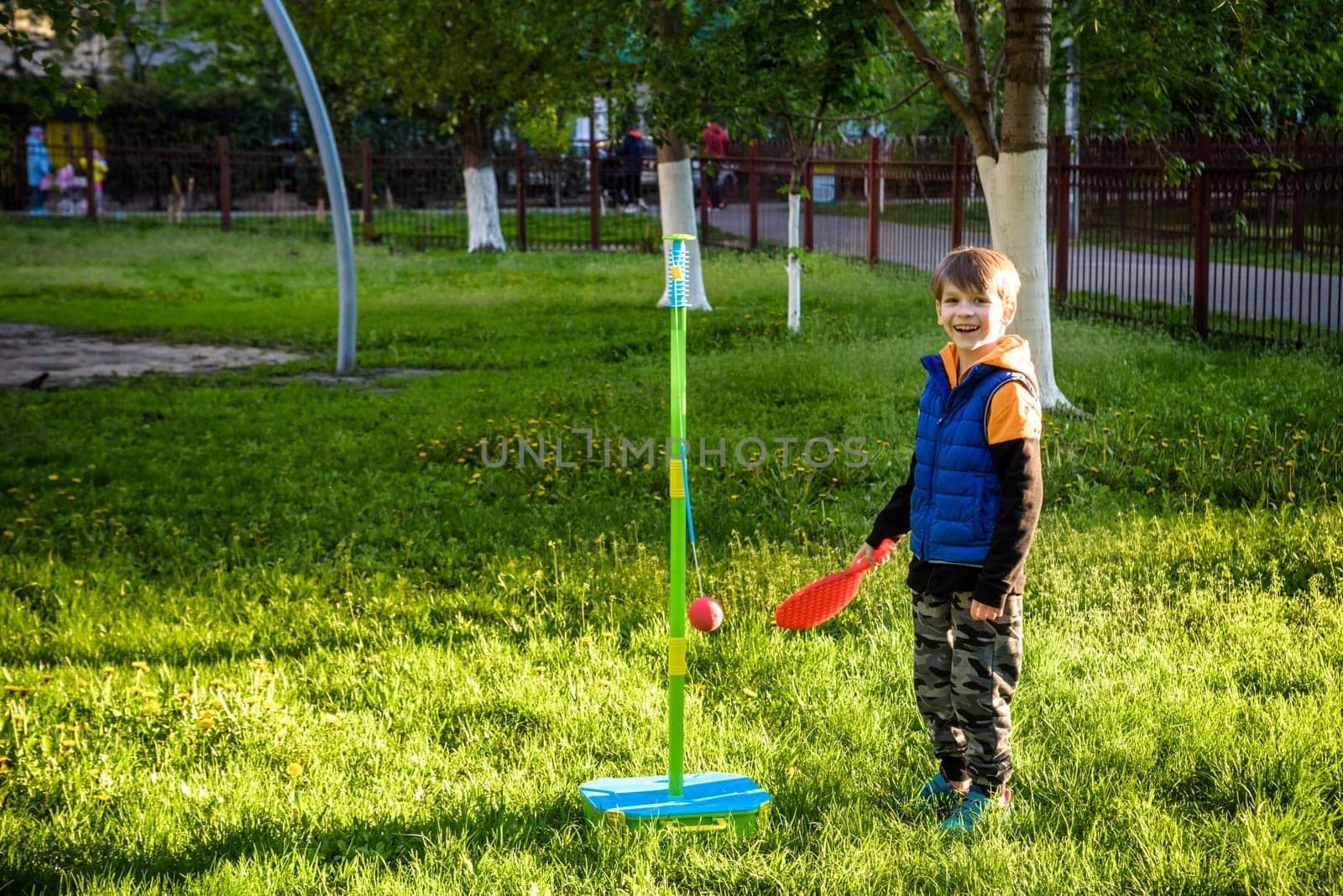 Happy boy is playing tetherball swing ball game in summer camping. Happy leisure healthy active time outdoors concept.