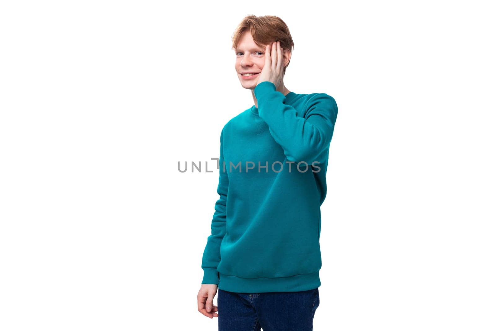 young cheerful smiling caucasian student guy with red hair in a blue sweater.