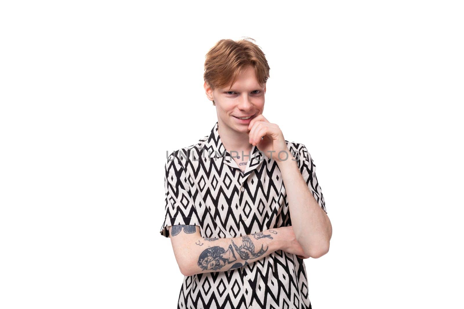 young stylish man with red hair is dressed in a short-sleeved shirt with a diamond pattern.