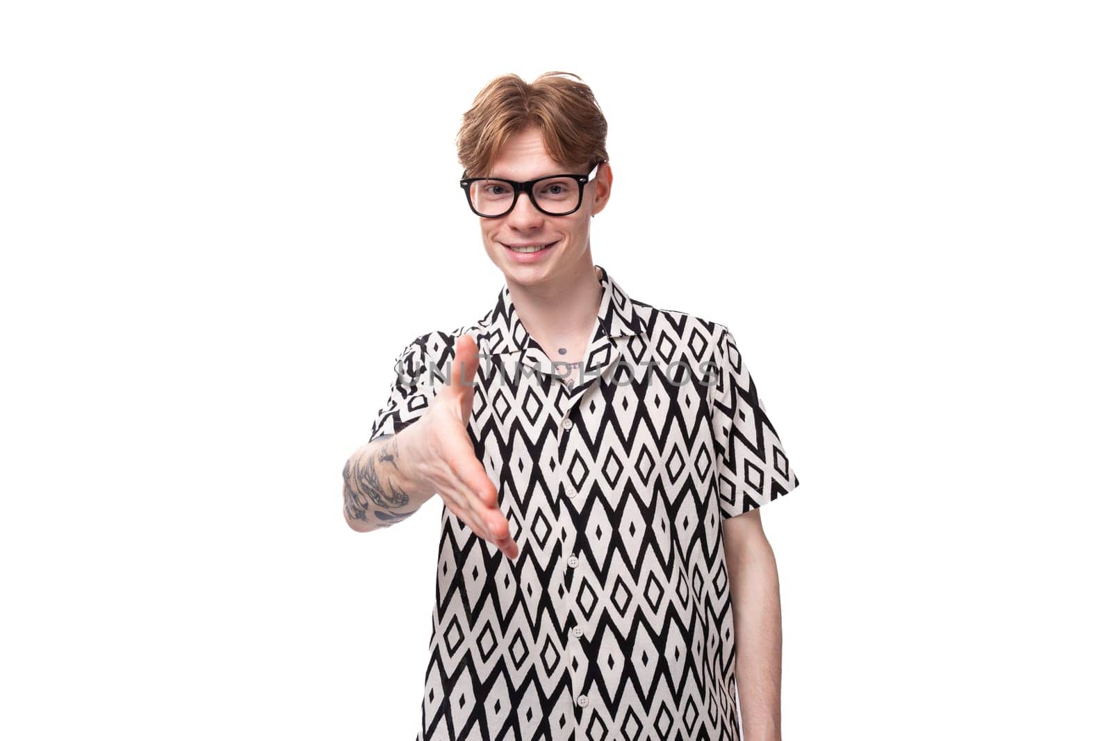 young surprised caucasian man with reddish golden hair in a black and white summer shirt on a white background with copy space.