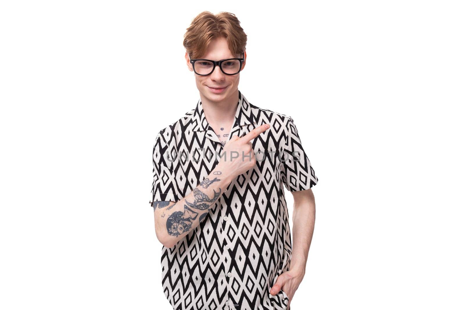 a young stylish man with red hair and a tattoo on his arms is dressed in a short-sleeve shirt with a diamond pattern by TRMK