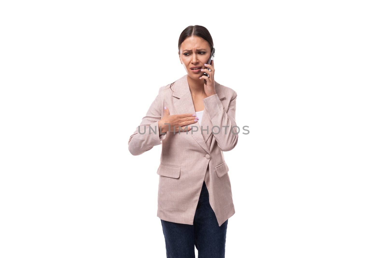 30 year old business woman with black hair wearing a beige jacket talking on the phone by TRMK