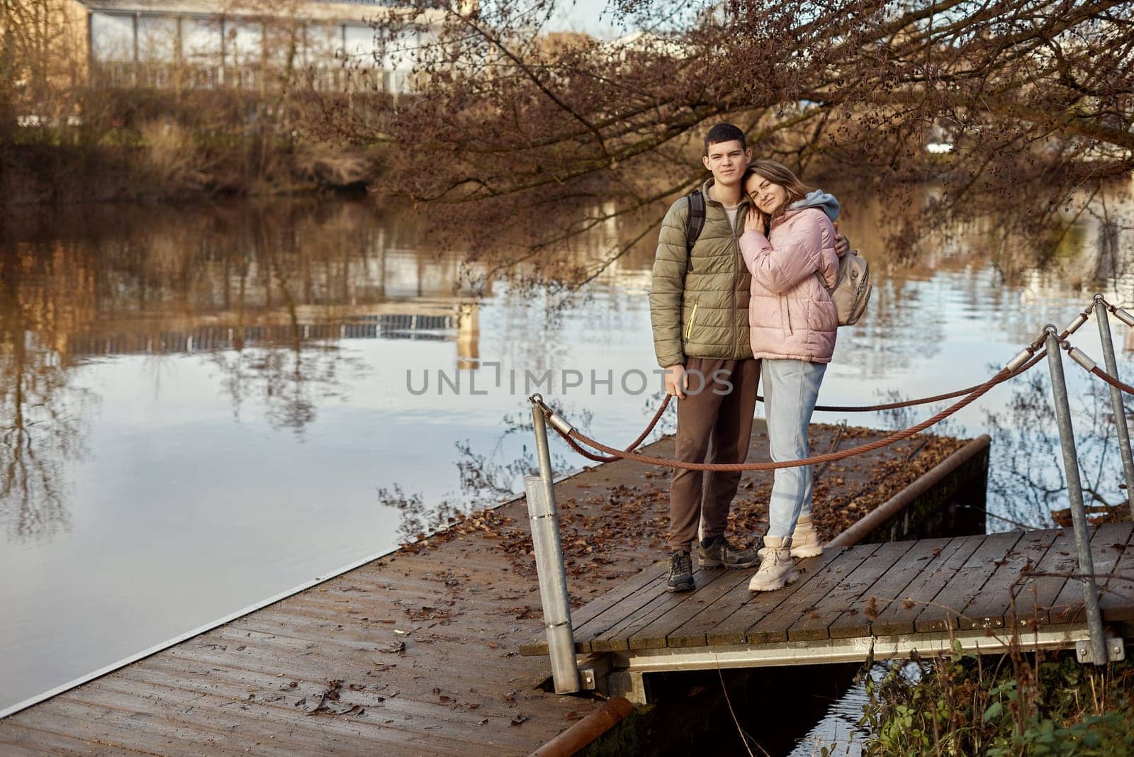 Embracing Moments: Beautiful 35-Year-Old Mother and 17-Year-Old Son in Winter or Autumn Park by Neckar River, Bietigheim-Bissingen, Germany. Celebrate the warmth of family love with this captivating image featuring a beautiful 35-year-old mother and her 17-year-old son embracing in the scenic park by Neckar River in Bietigheim-Bissingen, Germany. Whether touched by winter's chill or adorned with autumn hues, it's a timeless snapshot of familial connection amidst the enchanting surroundings