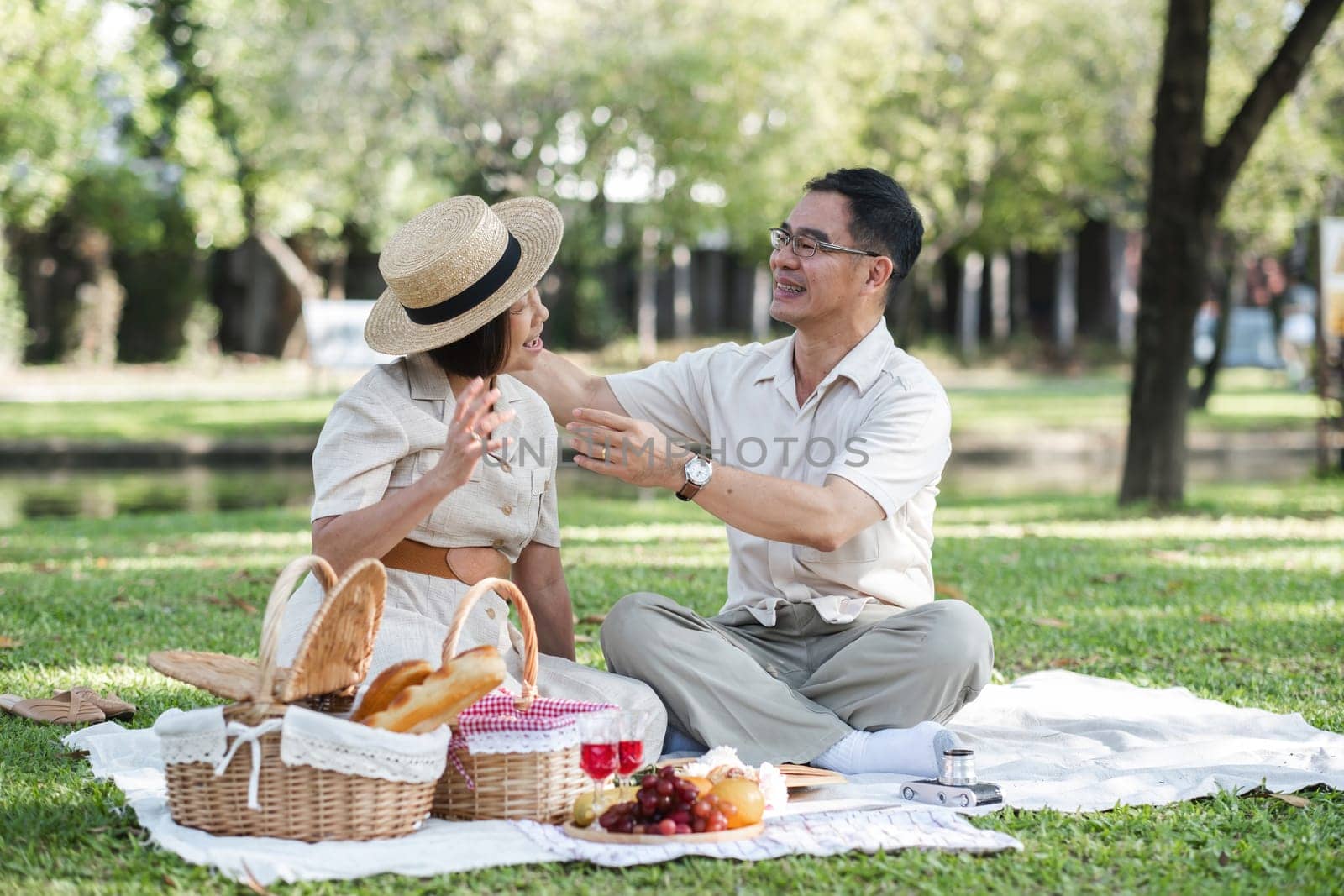 warm family There are parents and children doing picnic activities and relaxing outside together at the park on holidays. by wichayada