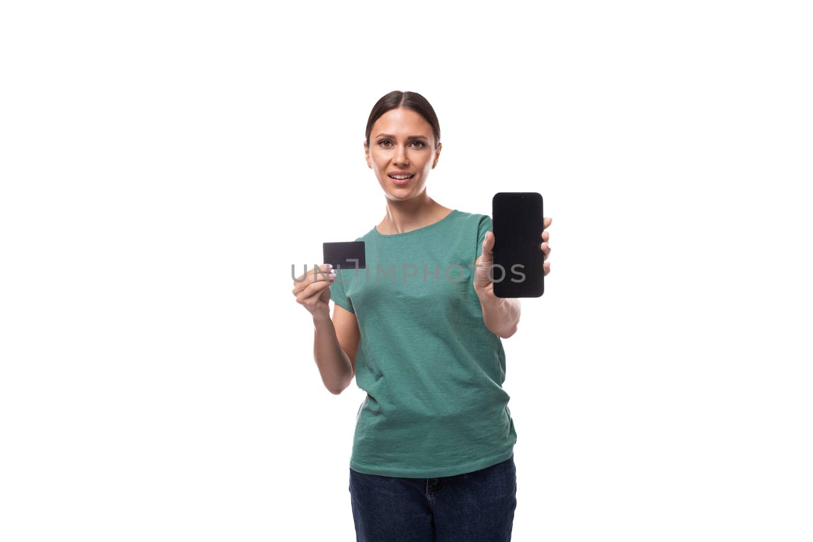 young brunette woman holding a plastic card with a mockup for discount and credit and a smartphone.