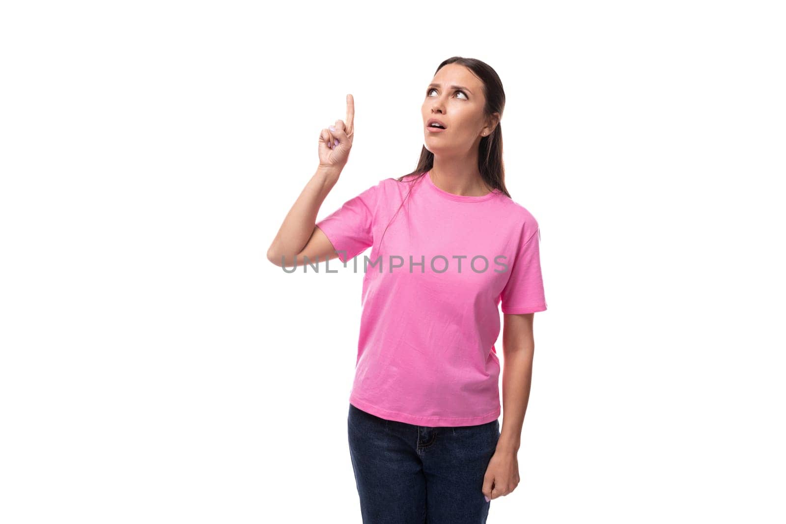 young beautiful model woman with straight black hair dressed in a pink t-shirt points her hand up.