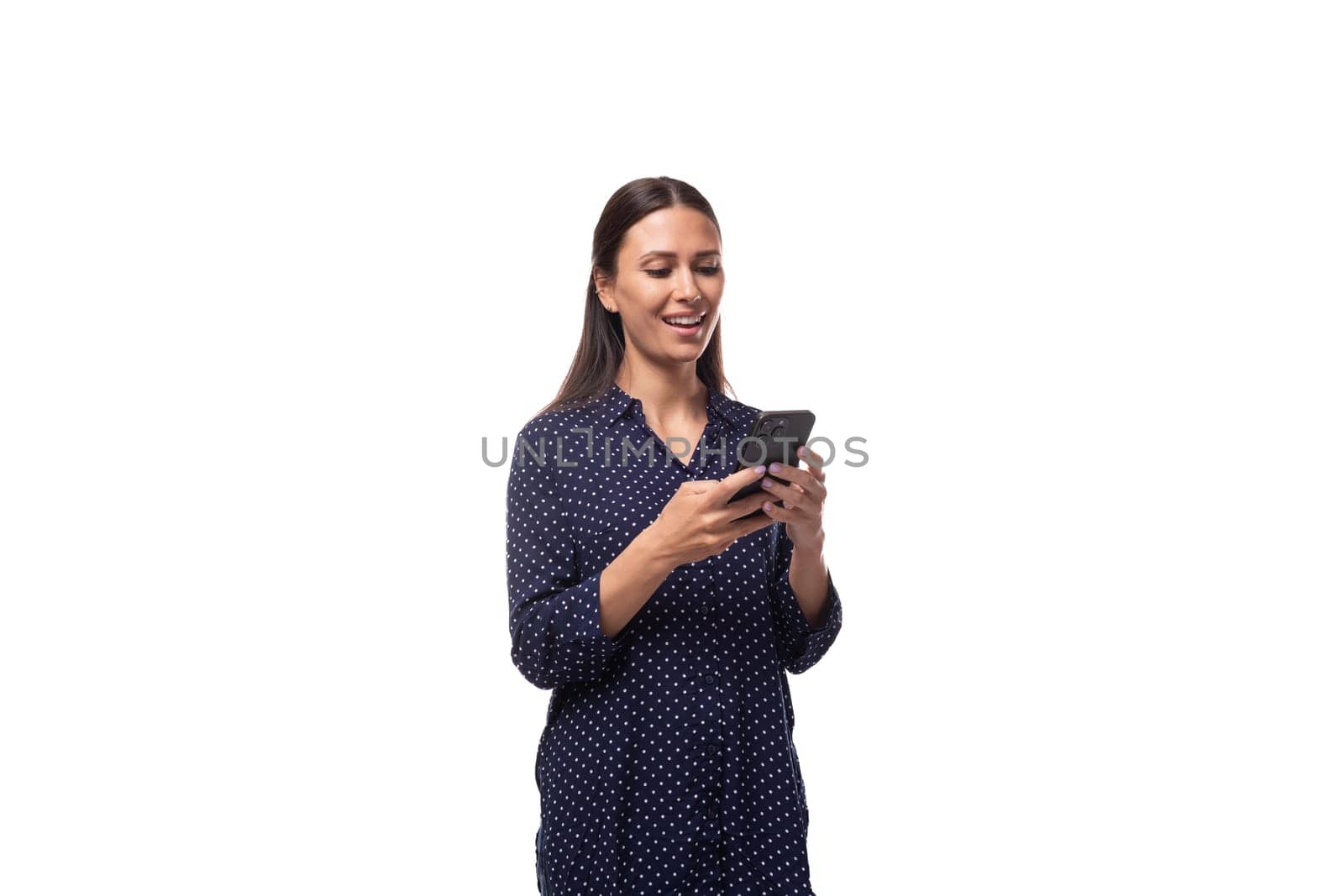 young charming cute brunette woman dressed in a blue blouse chatting in a smartphone by TRMK