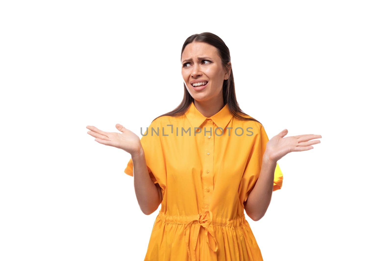 young caucasian brunette woman with long hair dressed in a yellow summer dress is trying to remember something important.