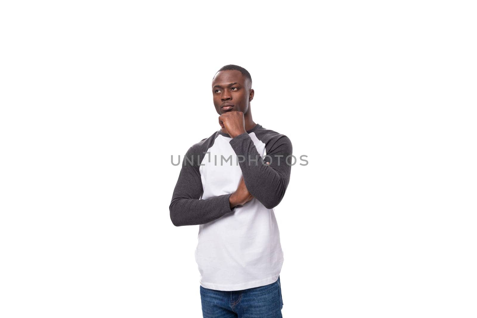 young american man with short haircut stands thoughtfully over isolated white background by TRMK