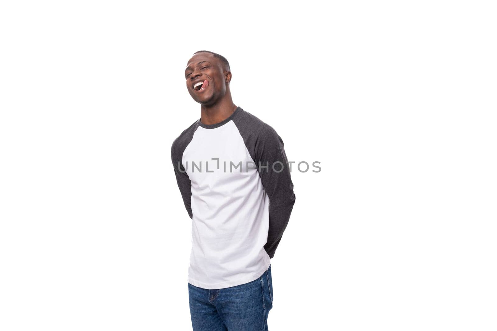 young african man with short haircut smiling cutely on studio background with copy space by TRMK