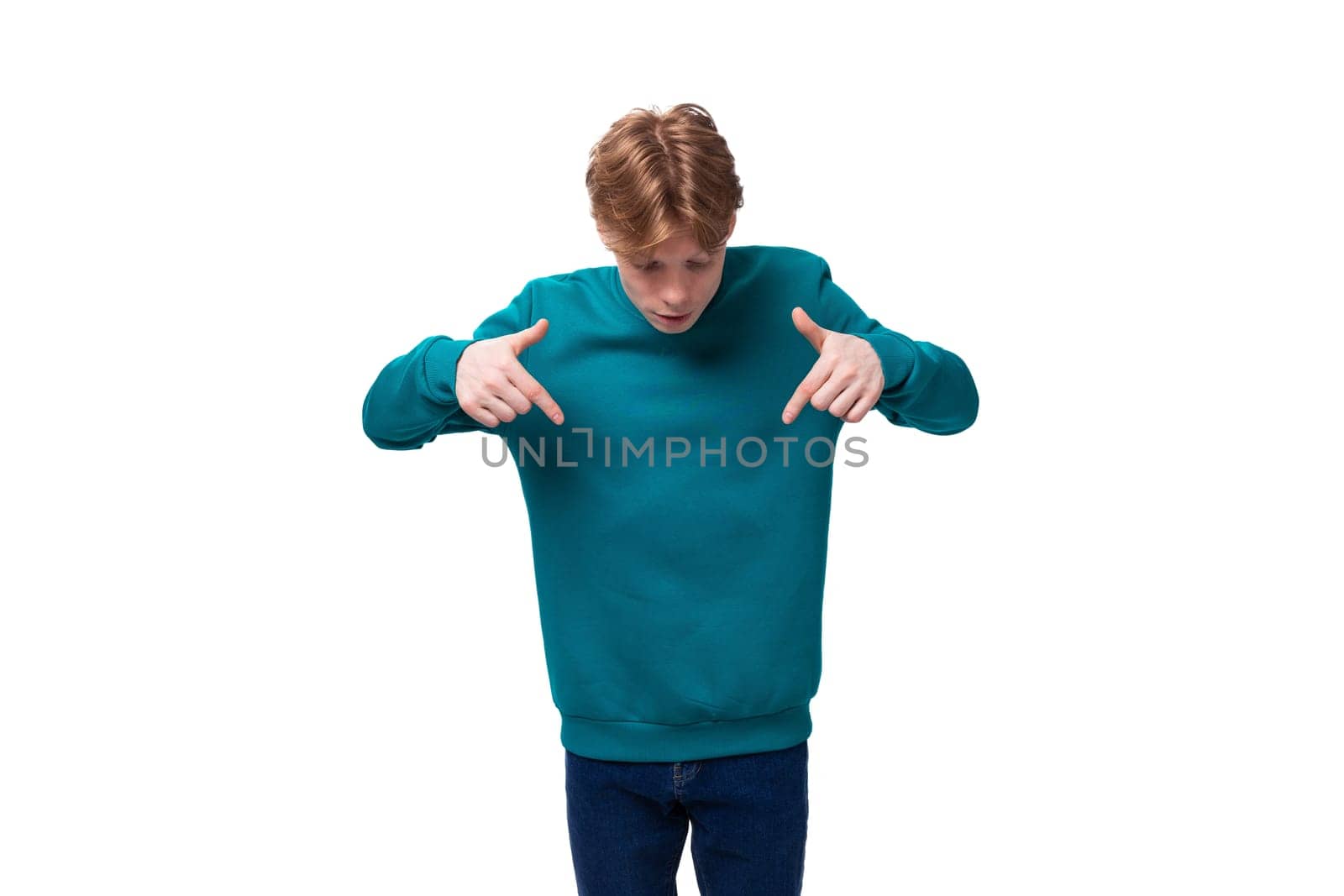 handsome red-haired young man in a blue sweater is surprised. advertising concept by TRMK