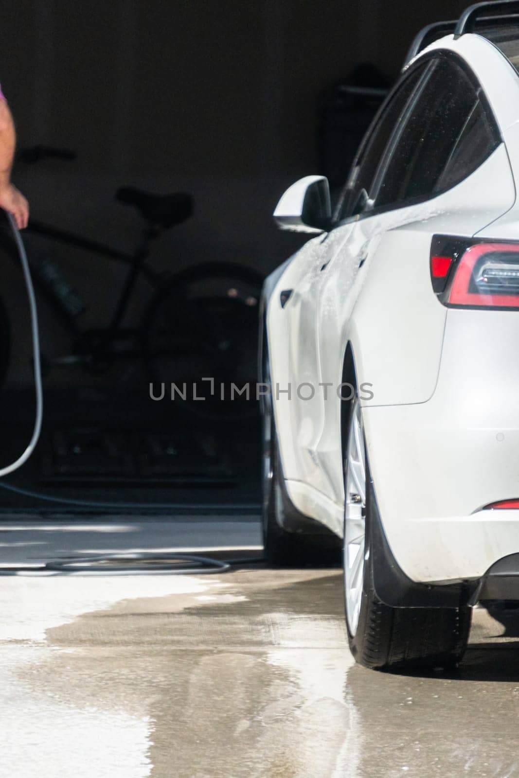 Efficiently cleaning an electric car in the comfort of a suburban driveway, combining eco-consciousness with practicality.