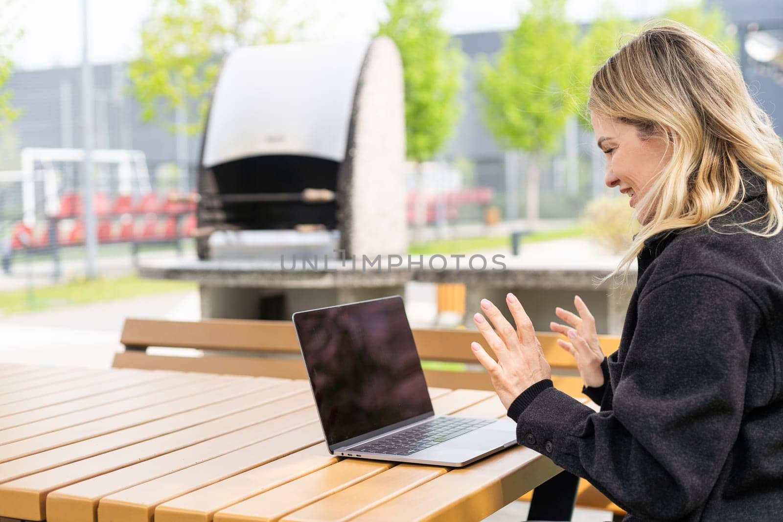 Young beautiful business woman sitting on a bench in the sunny city. High quality photo