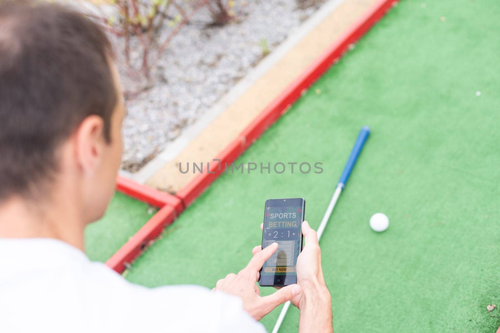 Touch screen in hand, tablet on golf club. smartphone with a sports betting application by Andelov13