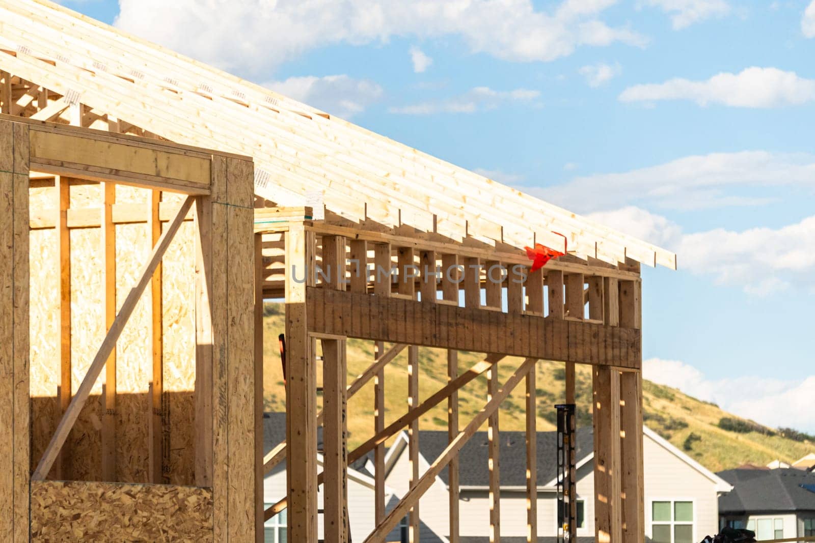 An ongoing construction site in the suburbs, featuring the framing stage of a single-family house.