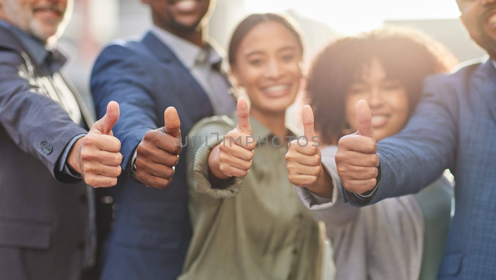 Business people, hands and teamwork with thumbs up in city for agreement, unity or approval. Support or group of happy employees with like emoji, yes sign or ok for thank you, good job or well done.