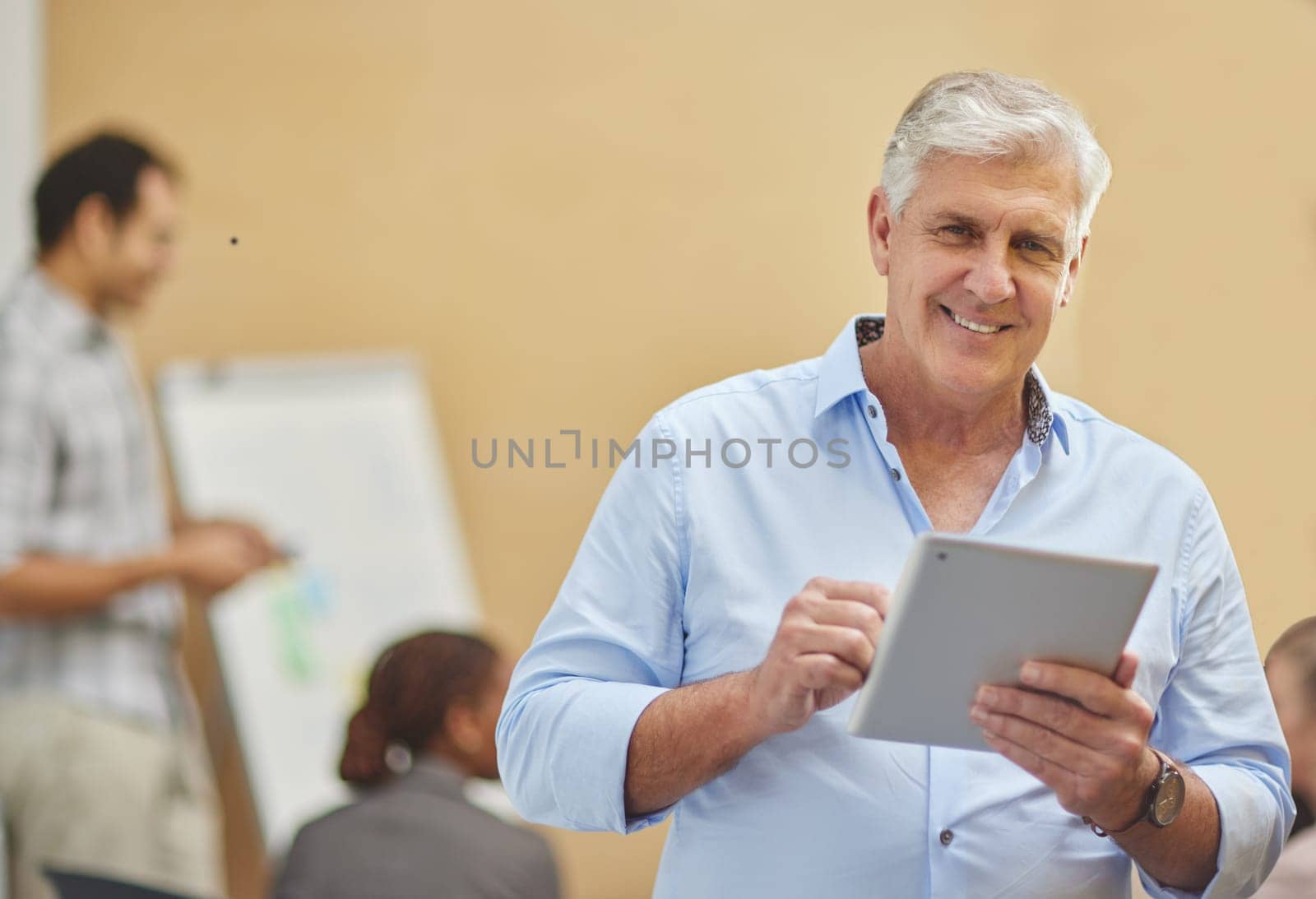 Office, portrait and mature businessman with tablet in workshop, presentation and coaching staff in meeting. Training, seminar and team manager with online research in startup with pride or happiness.