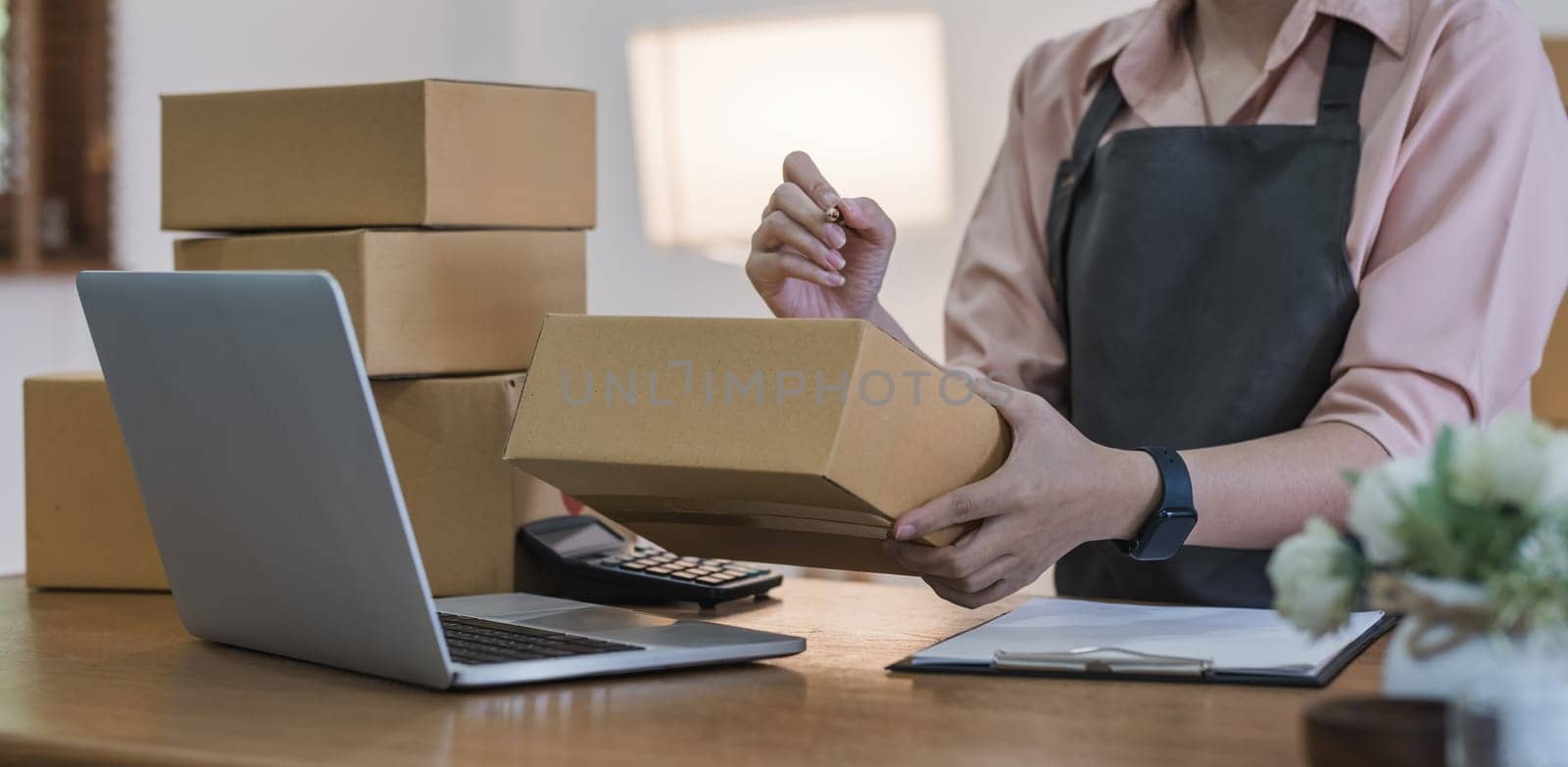 Business From Home Asian woman preparing package delivery box Shipping for shopping online. young start up small business owner at home online order by wichayada