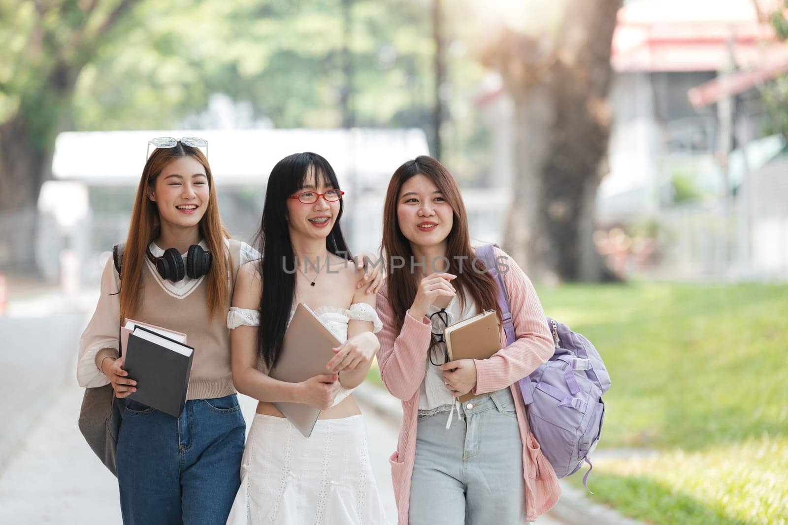 Group of Young Asian student walking and talking at university before class room. education, back to school concept by wichayada